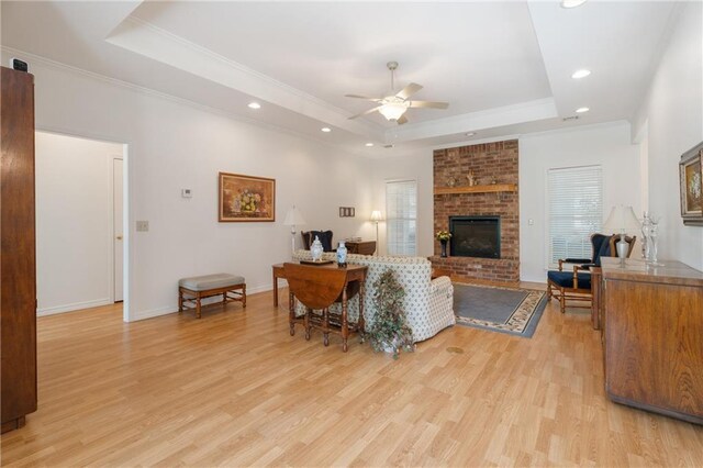 living area featuring a tray ceiling, light wood finished floors, a ceiling fan, and recessed lighting