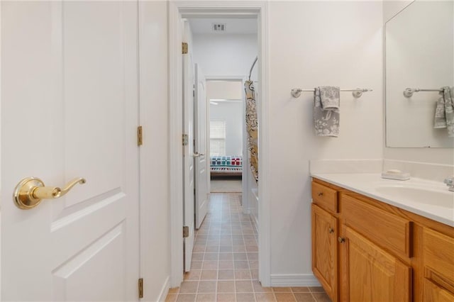 bathroom with baseboards, visible vents, tile patterned flooring, and vanity