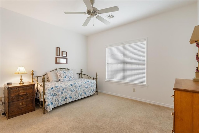 bedroom with baseboards, visible vents, light colored carpet, and ceiling fan