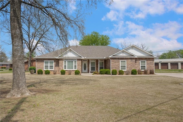 single story home featuring brick siding, roof with shingles, and a front lawn