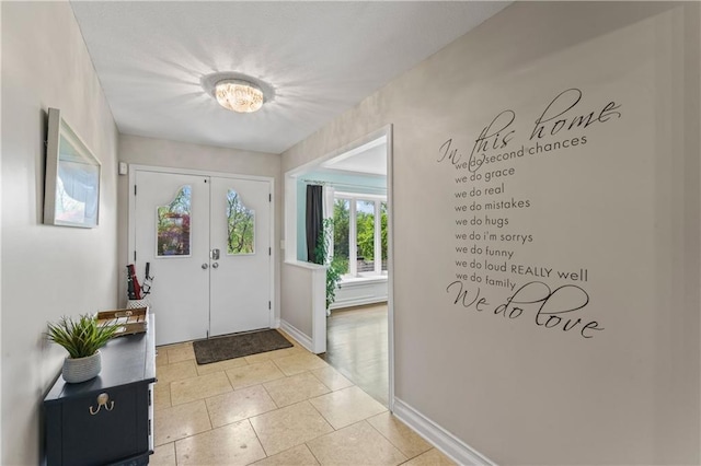entrance foyer with light tile patterned floors and baseboards