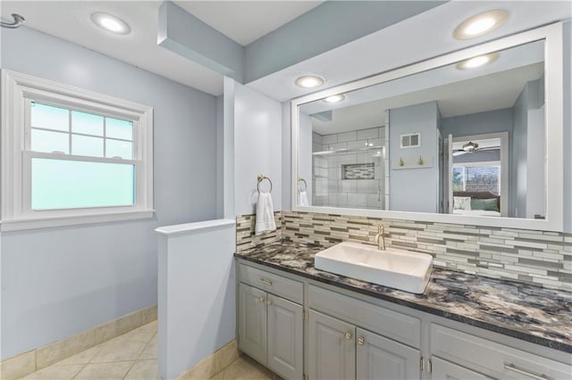 full bath with backsplash, baseboards, a shower stall, and vanity