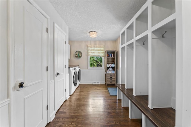 laundry area with cabinet space, dark wood-style flooring, a textured ceiling, visible vents, and washing machine and dryer