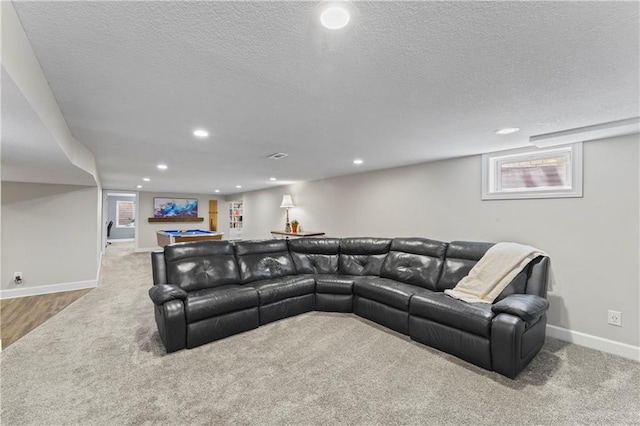 carpeted living room with a healthy amount of sunlight, baseboards, and a textured ceiling