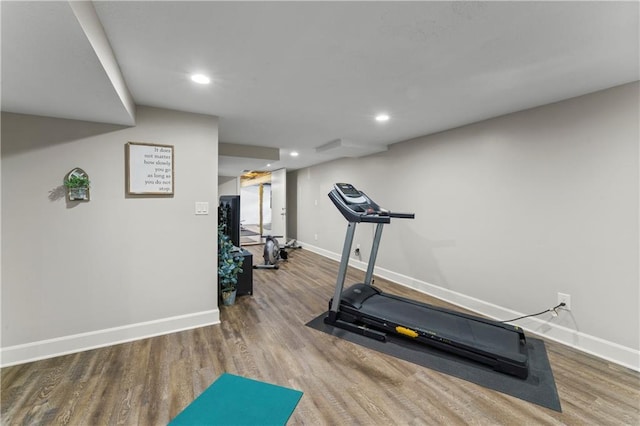 workout room with recessed lighting, baseboards, and wood finished floors