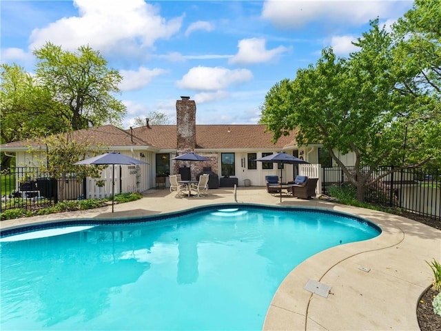 view of swimming pool with a patio, fence, and a fenced in pool