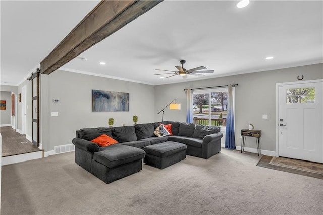 carpeted living room featuring recessed lighting, a barn door, plenty of natural light, baseboards, and ornamental molding