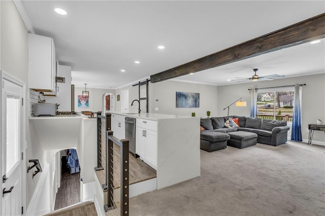 carpeted living room with a sink, recessed lighting, ceiling fan, crown molding, and arched walkways