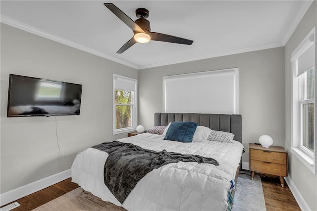 bedroom with wood finished floors, ornamental molding, baseboards, and a ceiling fan