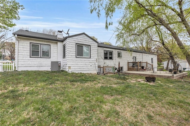 back of property featuring an outdoor fire pit, cooling unit, a wooden deck, a chimney, and a shingled roof