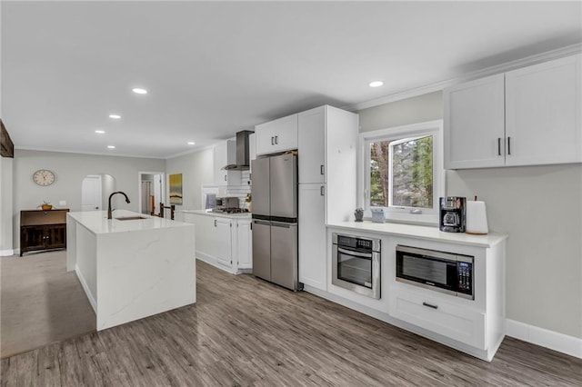 6025 Nall Ave, Mission, KS 66202 - kitchen with appliances with stainless steel finishes, wall chimney range hood, a sink, wood finished floors, and recessed lighting