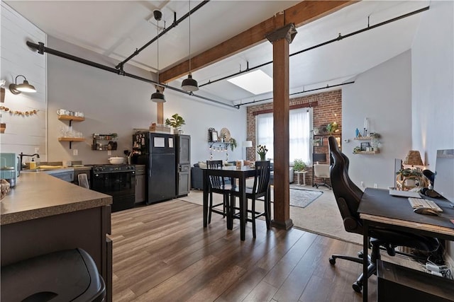 308 W 8th St Unit 505, Kansas City, MO 64105 - kitchen featuring beam ceiling, a sink, pendant lighting, light wood-style flooring, and black appliances