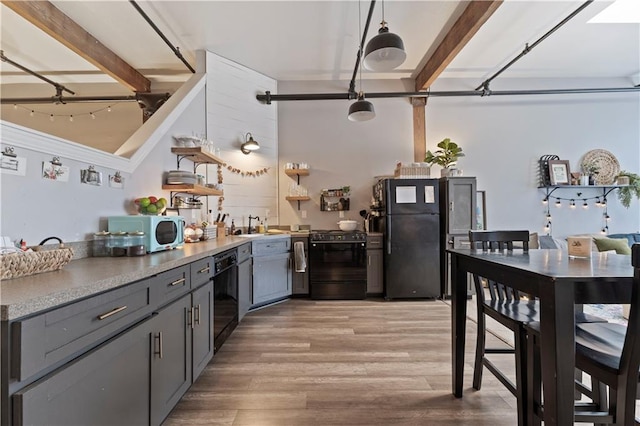 308 W 8th St Unit 505, Kansas City, MO 64105 - kitchen with a sink, open shelves, light wood-type flooring, beamed ceiling, and black appliances