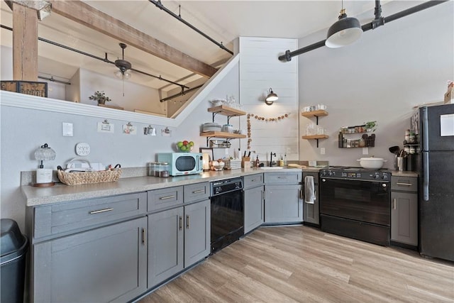 308 W 8th St Unit 505, Kansas City, MO 64105 - kitchen featuring light countertops, open shelves, gray cabinetry, light wood-style floors, and black appliances