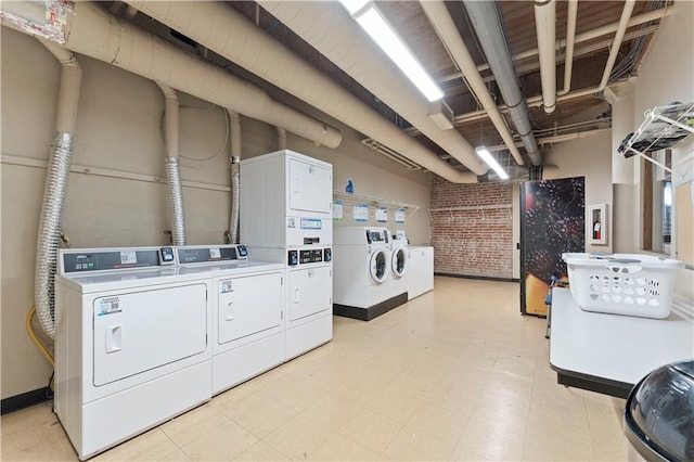 308 W 8th St Unit 505, Kansas City, MO 64105 - common laundry area with stacked washer / dryer, light floors, washer and clothes dryer, and brick wall