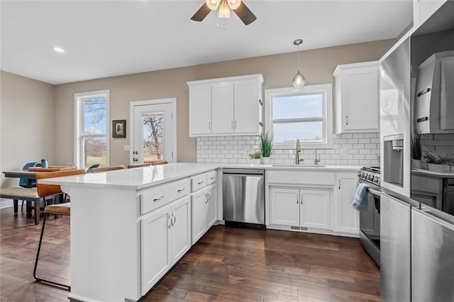 200 NW 180th St, Smithville, MO 64089 - kitchen featuring appliances with stainless steel finishes, a sink, a peninsula, light countertops, and white cabinetry