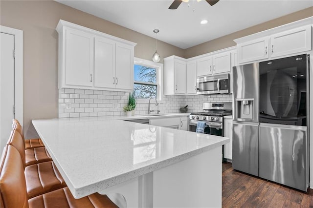 200 NW 180th St, Smithville, MO 64089 - kitchen featuring stainless steel appliances, a sink, a peninsula, a ceiling fan, and white cabinetry