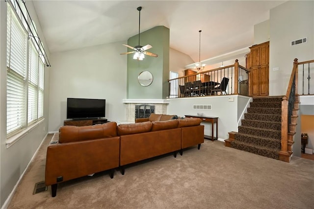 1216 SE Meridian Dr, Lees Summit, MO 64081 - carpeted living room featuring high vaulted ceiling, a ceiling fan, stairs, a tile fireplace, and baseboards