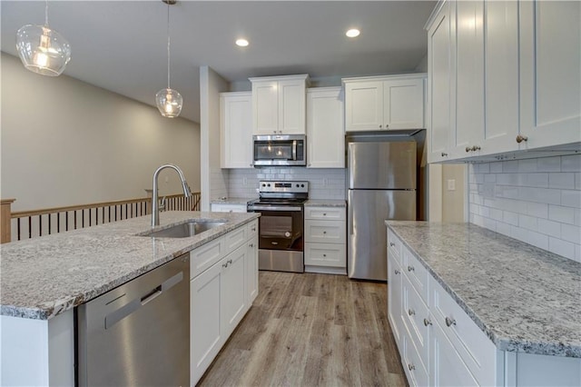 kitchen featuring a sink, light wood-type flooring, white cabinets, and appliances with stainless steel finishes