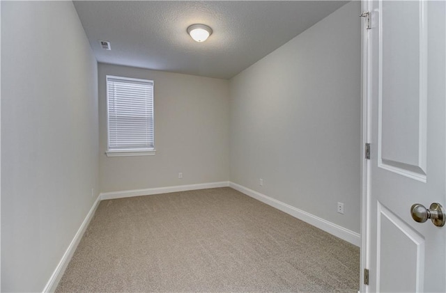 unfurnished room with baseboards, carpet flooring, a textured ceiling, and visible vents