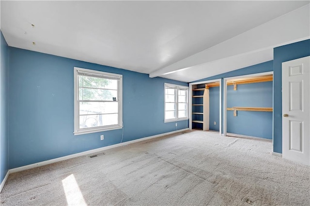 unfurnished bedroom featuring two closets, baseboards, carpet flooring, and visible vents