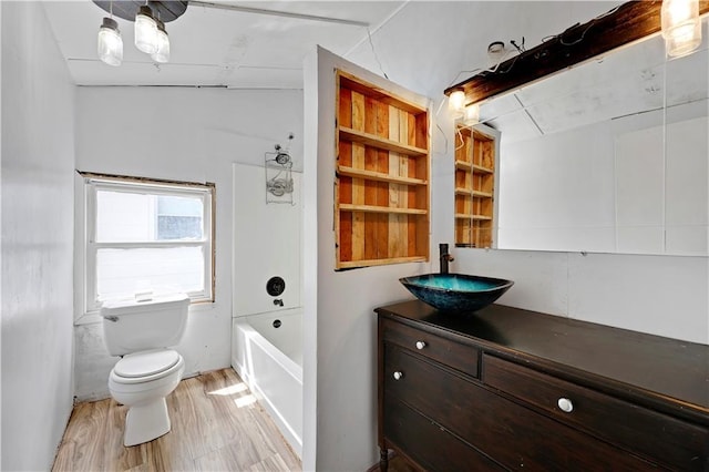 full bathroom with wood finished floors, toilet, vanity, and shower / washtub combination