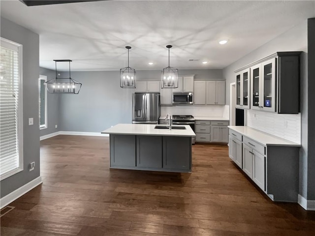 kitchen with dark wood-style flooring, decorative backsplash, a sink, and stainless steel appliances