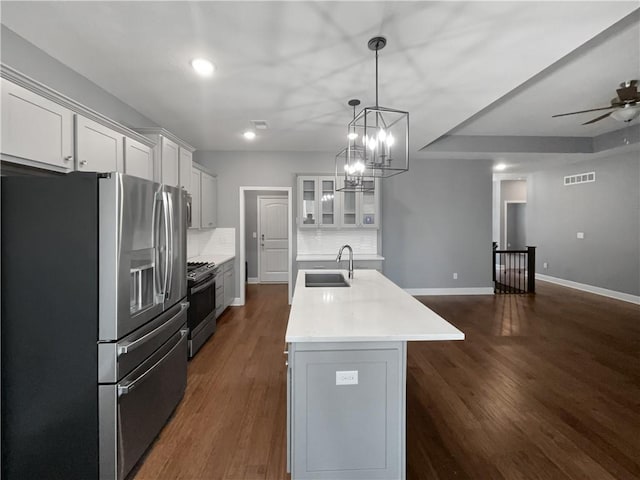 kitchen featuring light countertops, decorative backsplash, a sink, visible vents, and appliances with stainless steel finishes