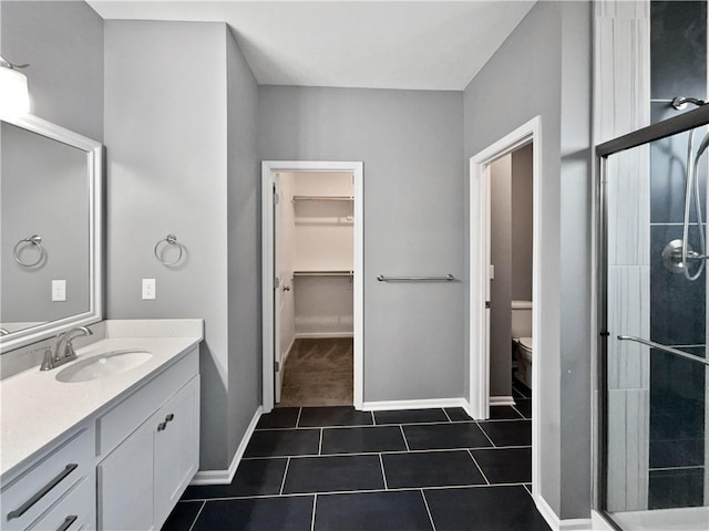 full bath with toilet, vanity, a walk in closet, and a shower stall
