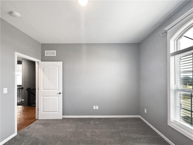 unfurnished bedroom featuring carpet flooring, baseboards, and visible vents