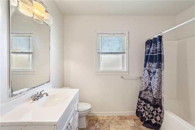 full bath featuring vanity, toilet, baseboards, and a healthy amount of sunlight