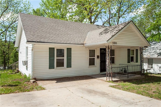 view of front facade with a porch, a shingled roof, and driveway