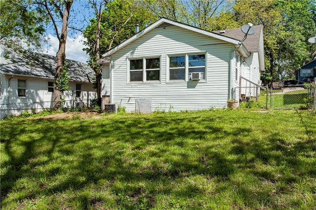view of side of property with cooling unit, a yard, fence, and central AC