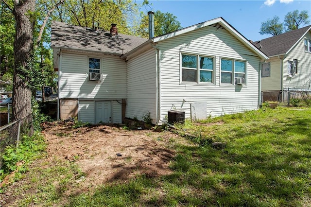 back of property with fence, central AC, a yard, cooling unit, and a chimney