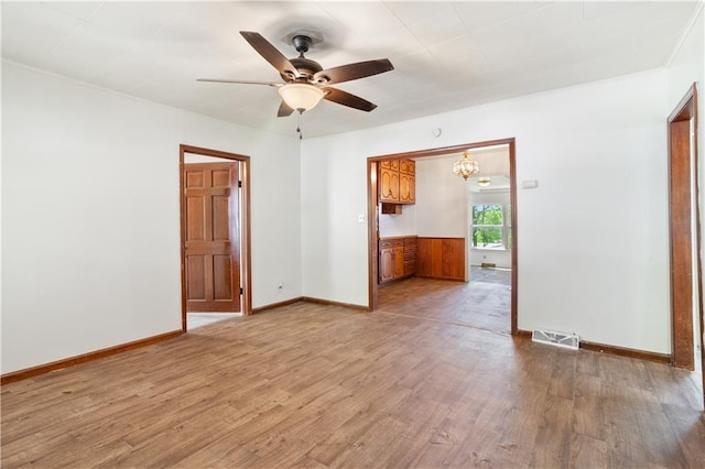 spare room with baseboards, visible vents, wood finished floors, and a ceiling fan