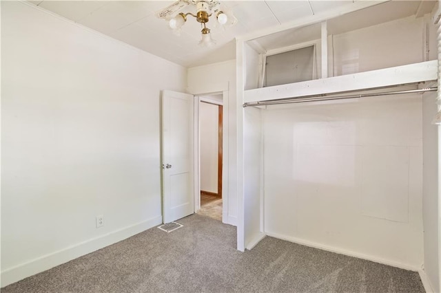 unfurnished bedroom with a closet, visible vents, baseboards, and carpet floors