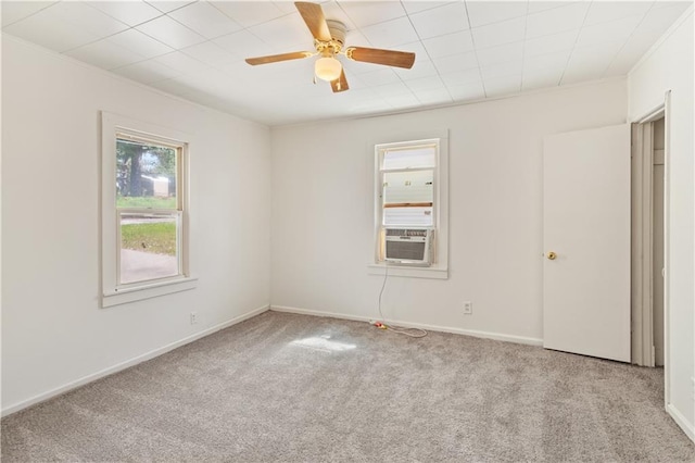 empty room with cooling unit, carpet, baseboards, and a ceiling fan