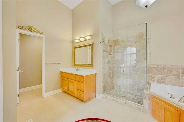full bathroom featuring tile patterned flooring, vanity, baseboards, a shower stall, and a bath