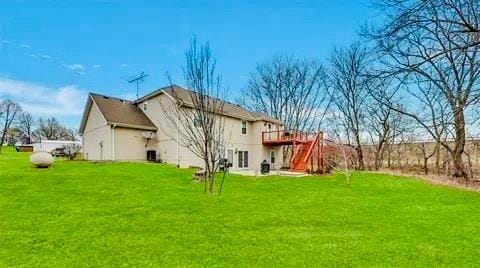 rear view of property featuring stairs, a wooden deck, and a yard