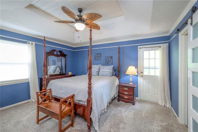 carpeted bedroom featuring a barn door, a raised ceiling, a textured ceiling, ceiling fan, and baseboards