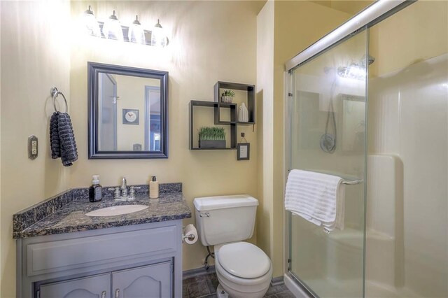 bathroom featuring a stall shower, toilet, and vanity