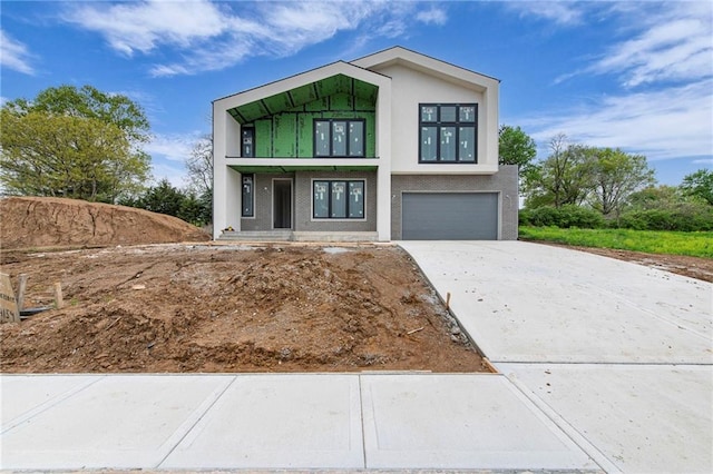 contemporary home with stucco siding, driveway, and an attached garage