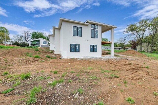 rear view of property featuring stucco siding