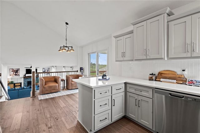kitchen with dark wood-style flooring, light countertops, a peninsula, dishwasher, and gray cabinets