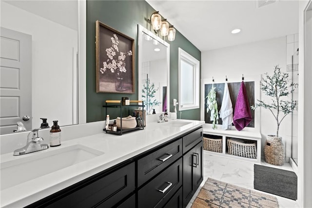 bathroom with recessed lighting, marble finish floor, a sink, and double vanity