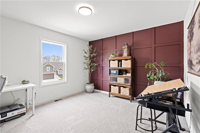 carpeted office featuring a decorative wall, baseboards, and visible vents
