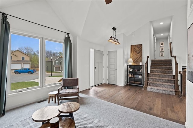 entryway with lofted ceiling, stairway, baseboards, visible vents, and wood finished floors