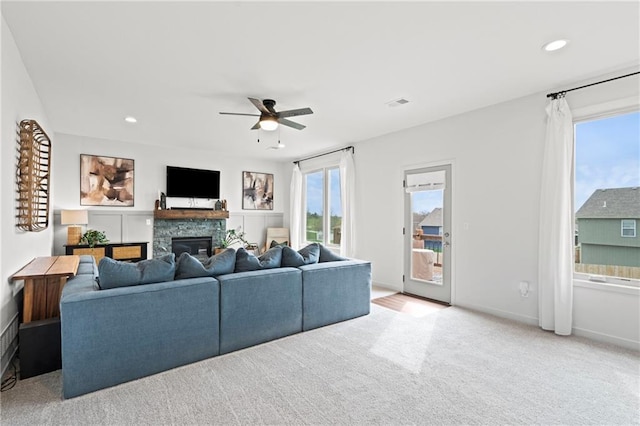 living area featuring a stone fireplace, visible vents, ceiling fan, and recessed lighting