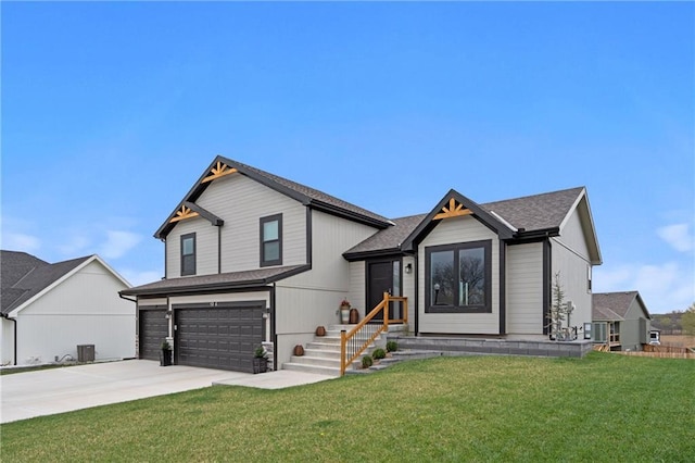 view of front of home with driveway, an attached garage, central AC, and a front yard