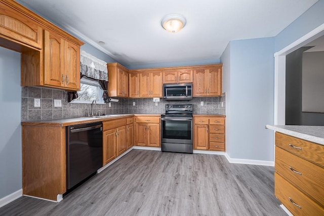 953 N Hickory Dr, Tonganoxie, KS 66086 - kitchen featuring appliances with stainless steel finishes, light wood-style flooring, baseboards, backsplash, and a sink